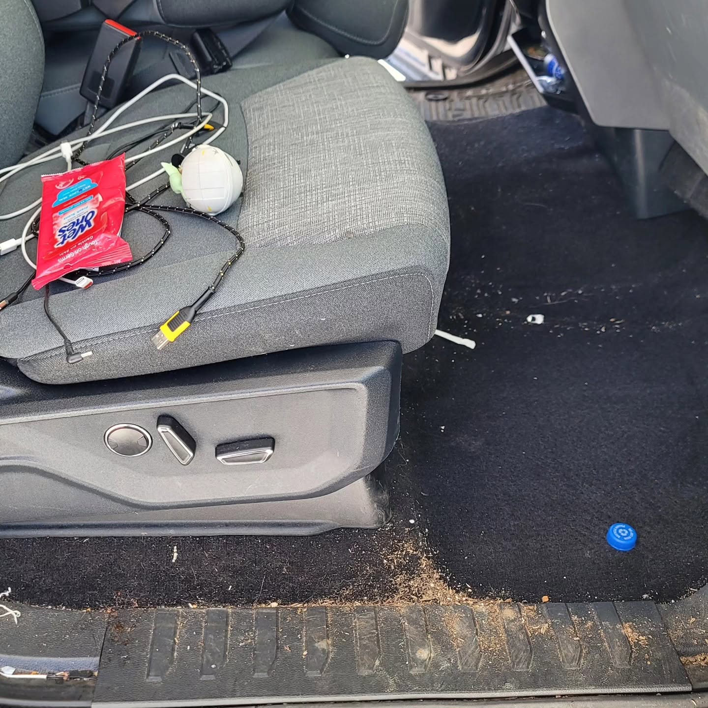 Stained car seat and dirty carpet before interior detailing in San Francisco
